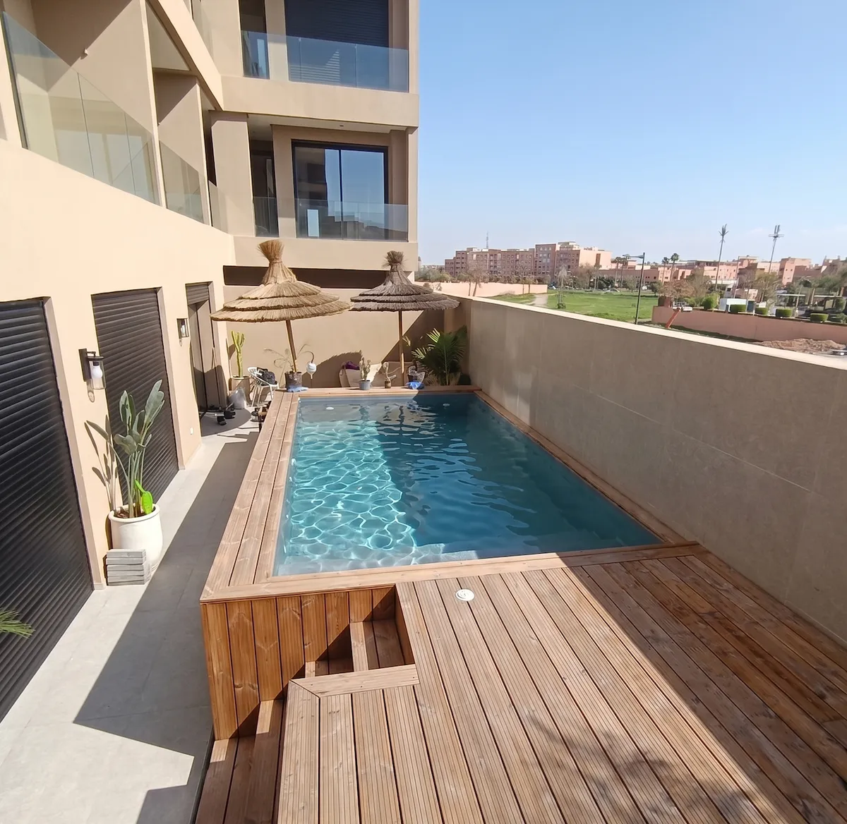 Piscine hors-sol en polyester habillée de bois sur une terrasse à Marrakech